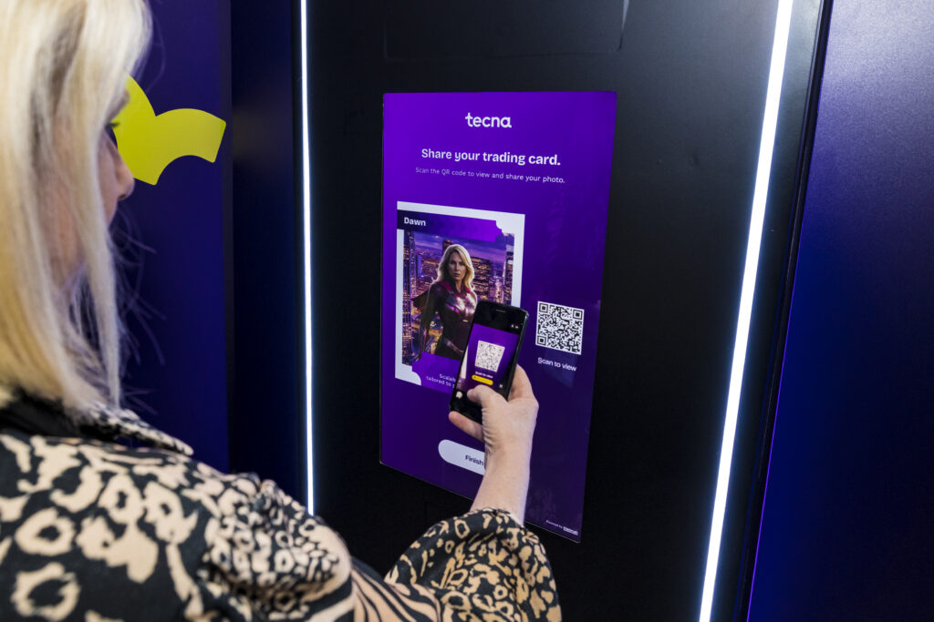 A visitor scanning a screen using a digital lead capture device at a trade show.
