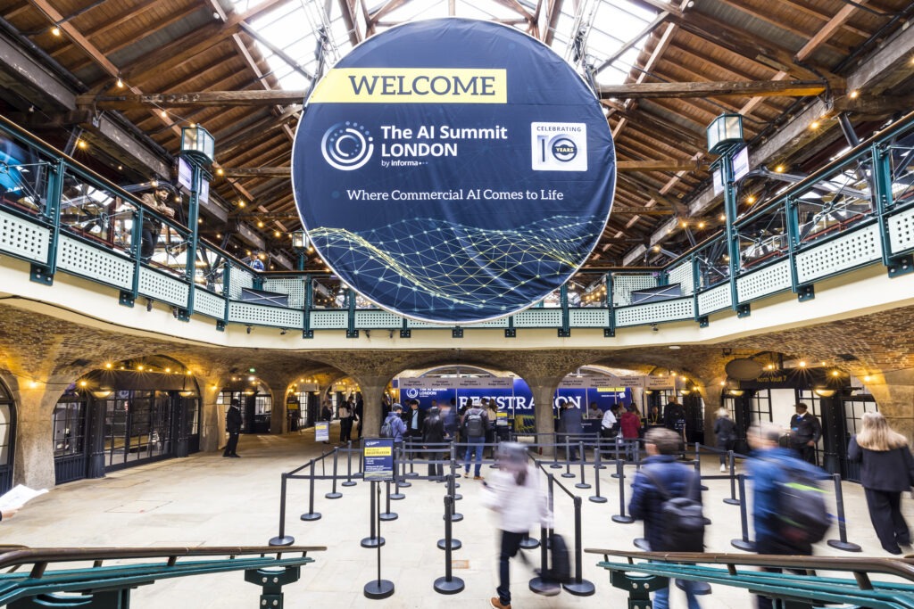 Busy entrance to a UK exhibition venue showing the AI Summit London signage, illustrating the scale and infrastructure of major UK trade shows.