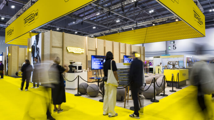 Bold yellow exhibition stand design with suspended branded signage, illustrating how standout exhibition stands attracts visitor attention at UK trade shows