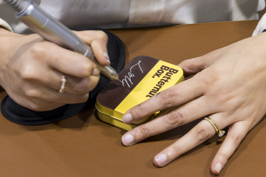Branded Butternut Box tin being personalised with an engraved name at a trade show